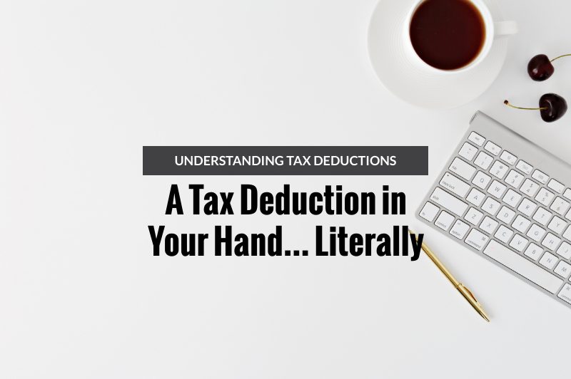 a tax deduction in your hand literally blog header on desk